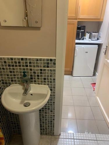 a bathroom with a sink and a tiled floor at Private Studio near Dublin City in Dublin