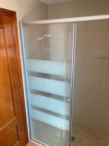 a shower with a glass door in a bathroom at Pensión Dani in Casinos