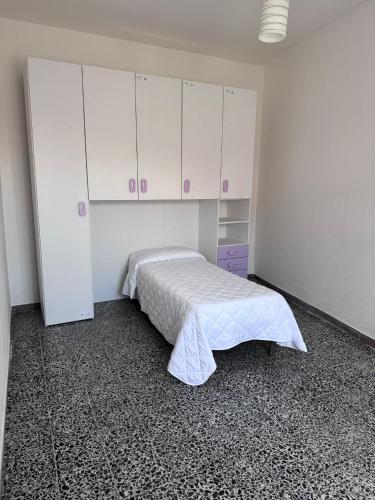 a bedroom with a bed and white cabinets at Tepilora in Torpè