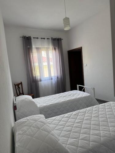 a bedroom with two beds and a window at Tepilora in Torpè