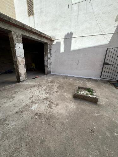 an empty garage with a brick wall and a door at Tepilora in Torpè