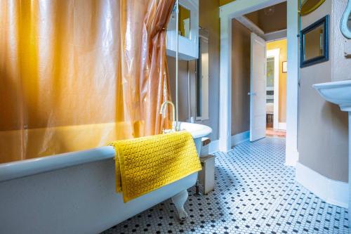 a bathroom with a yellow shower curtain and a tub and sink at Bisbee Home Fantastic Views and Walkable Location! in Bisbee