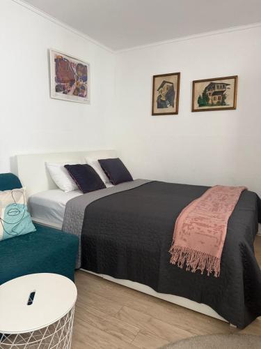 a bedroom with two beds and a table and a couch at Studio Apartments Siesta in Sarajevo
