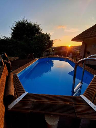 une grande piscine bleue entourée d'un banc en bois dans l'établissement Maison climatisée au calme proche des commerces, à Baume-les-Dames