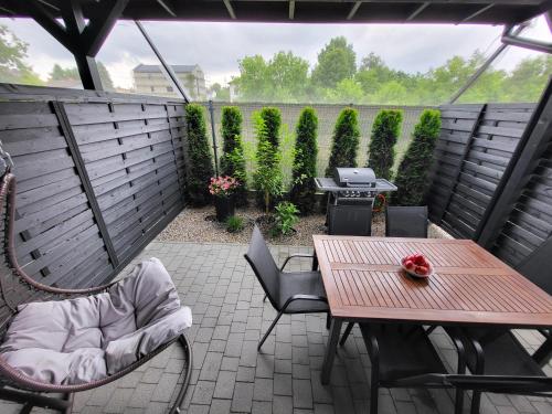 a patio with a table and chairs and a grill at Lipowy Zakątek - domki blisko Energylandii i stacji PKP w Zatorze in Zator