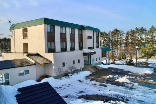 a building with a lot of snow in front of it at Hotel Sol at Lake Toya in Lake Toya