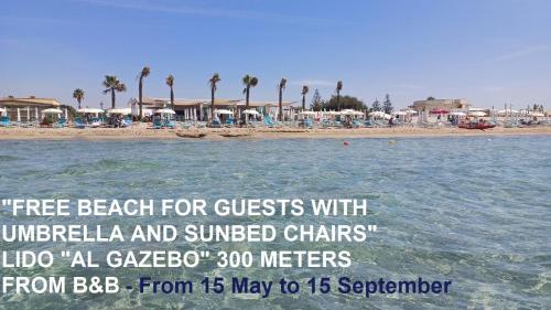 a poster for a beach for guests with umbrellas andsurrendered chairs at Anastasia Villas-B&B in Lido Signorino