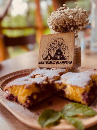 a plate of food with a piece of cake on a table at Mesteceni Glamping in Nistoreşti