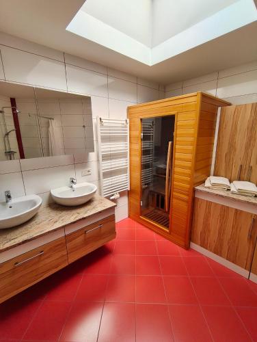 baño con 2 lavabos y suelo de baldosa roja en Penthaus Appartement, en Sankt Michael im Lungau