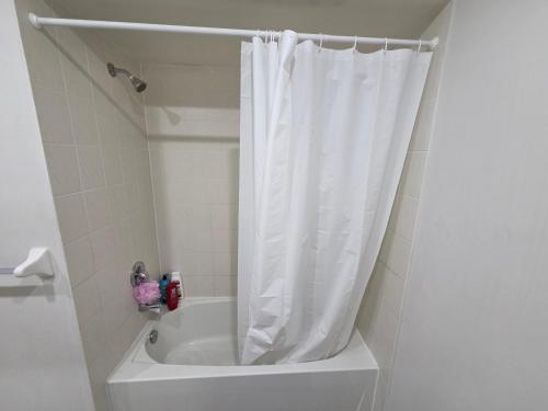 a white shower curtain in a bathroom with a tub at Four Bedroom Spacious House with Parking in Milton, Ontario in Milton