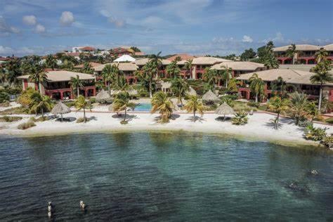 Una playa con árboles y sombrillas y un resort. en Spanish Water View Apartment, en Willemstad