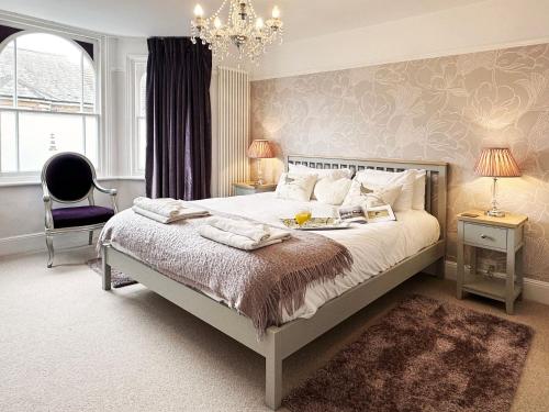 ein Schlafzimmer mit einem großen Bett und einem Kronleuchter in der Unterkunft Lighthouse View by The Suffolk Cottage Collection in Southwold