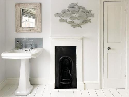 ein Badezimmer mit Waschbecken und schwarzem Türrahmen in der Unterkunft Lighthouse View by The Suffolk Cottage Collection in Southwold