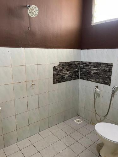 a bathroom with a shower and a toilet at Homestay Taman Delima Paka in Kampong Gong Gemia