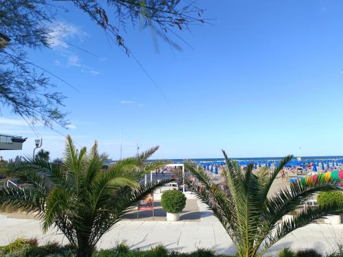 a view of a beach with palm trees at SUITEHOME Comfort Apartment near the Beach in Rimini