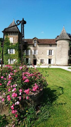 a large building with pink flowers in front of it at Pierre Deluen Domaine de la Grange de Quaire in Chassenon