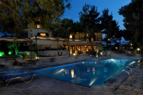 a swimming pool in a resort at night at Heos Accommodation in Ormos Panagias