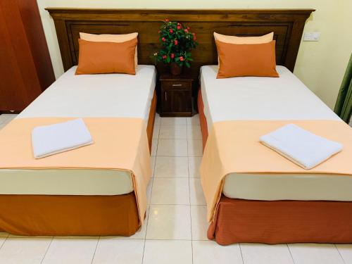 two beds sitting next to each other in a room at Marigold Negombo in Negombo