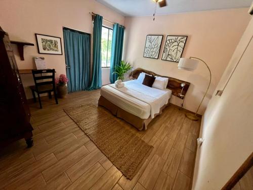 a bedroom with a bed and a table and a chair at Kika Zaru Free park tour, massage and breakfast in Quepos