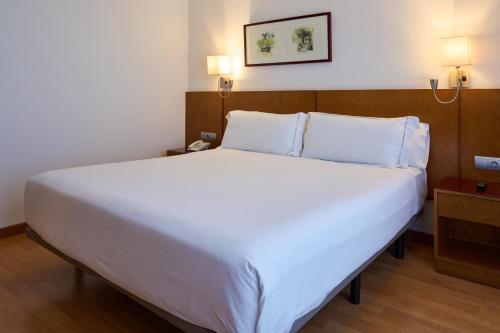 a large white bed in a hotel room at Senator Granada in Granada