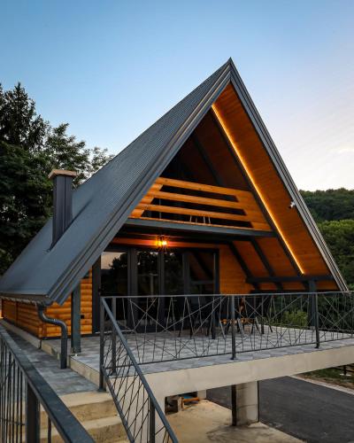 a house with a large gambrel roof with a deck at Nale Luxury Chalet in Bratunac