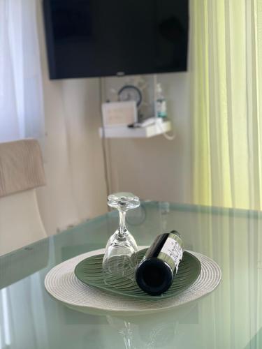 a plate with a wine glass and a bottle on a table at Apartmani Marković RAB in Palit