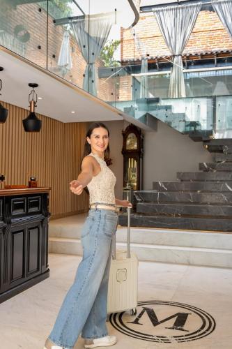 a woman standing in a room with a suitcase at The Mark Hotel in Mexico City