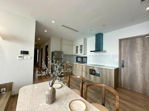 a kitchen with a table with a vase of flowers on it at Swanlake ecopark Hanoi-Calm homestay in Kim Quan