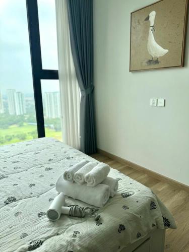 a bedroom with a bed with towels and a window at Swanlake ecopark Hanoi-Calm homestay in Kim Quan