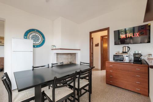 a dining room with a black table and chairs at Villa Vinci in Campu Longu