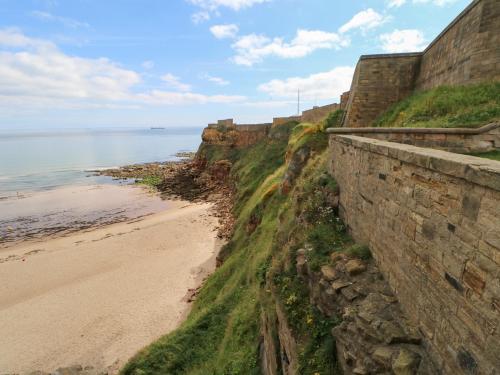 a retaining wall next to a beach next to the ocean at Marden Mews in Whitley Bay