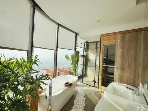 a bathroom with a tub and a large window at Swanlake ecopark Hanoi-Calm homestay in Kim Quan