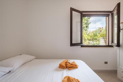 a bedroom with a white bed with a towel on it at Villa Vinci in Campu Longu