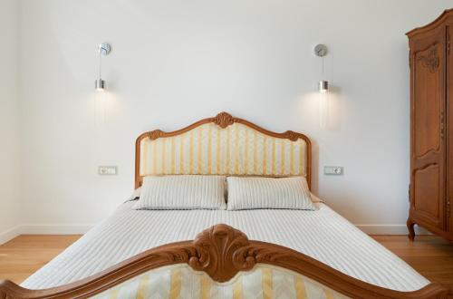 1 cama grande en un dormitorio con cabecero de madera en Central Apartment, en Birštonas