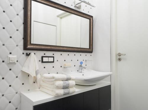 a bathroom with a sink and a mirror at Central Apartment in Birštonas