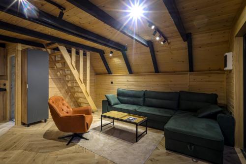 a living room with a green couch and a chair at Nale Luxury Chalet in Bratunac
