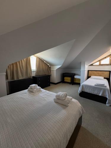a bedroom with two beds with towels on them at Swiss Holiday in Budva