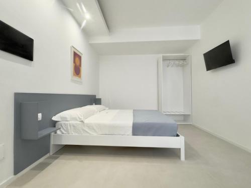 a bedroom with a bed in a white room at Fata Morgana Guest Rooms in Diamante