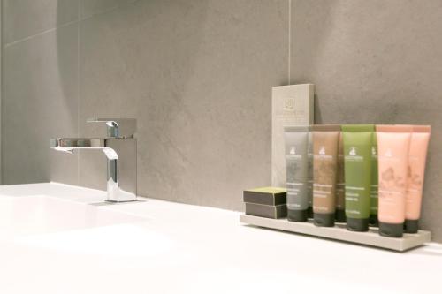 a bathroom sink with a rack of books next to a faucet at Teatro Romano 4 & 5 in Málaga