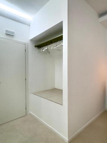 a room with white walls and a closet with shelves at Fata Morgana Guest Rooms in Diamante