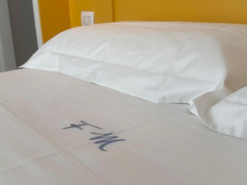 a white bed with white pillows on top of it at Fata Morgana Guest Rooms in Diamante