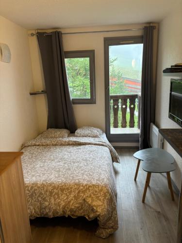 une chambre avec un lit et une fenêtre dans l'établissement Studio cabine au pied des pistes, à Modane
