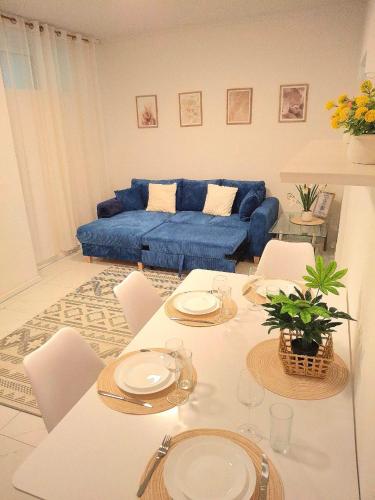 a living room with a table and a blue couch at Family Design Apartments Neunkirchen - 2 rooms Apartment 5 in Neunkirchen