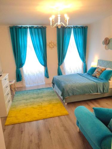 a bedroom with two beds and blue curtains at Family Design Apartments Neunkirchen - 2 rooms Apartment 5 in Neunkirchen