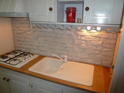 a kitchen with a sink and a stove at Les Bruyères du Mont in Céaux