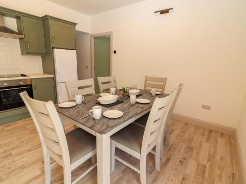 a dining room with a table and chairs in a kitchen at Teach Ti in Miltown Malbay