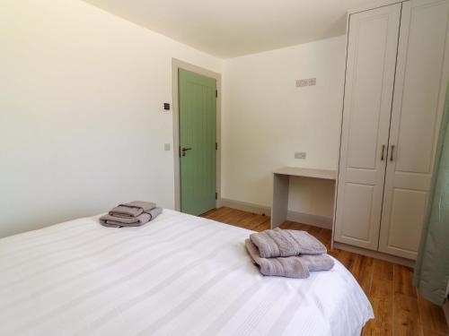 a bedroom with a white bed with towels on it at Teach Ti in Miltown Malbay