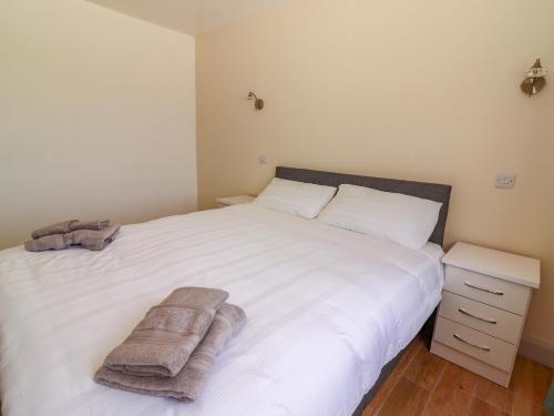 a bedroom with a white bed with towels on it at Teach Ti in Miltown Malbay
