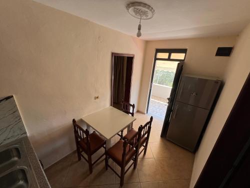 a dining room with a table and chairs and a window at Villa Bebi in Sarandë