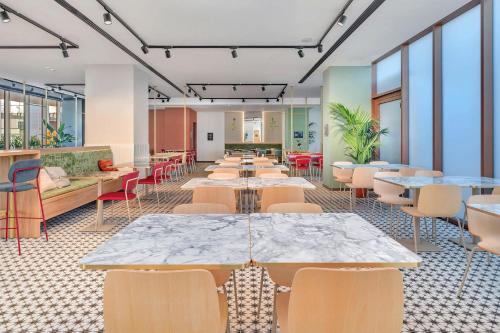 a cafeteria with tables and chairs and windows at B&B HOTEL Venezia Laguna in Venice
